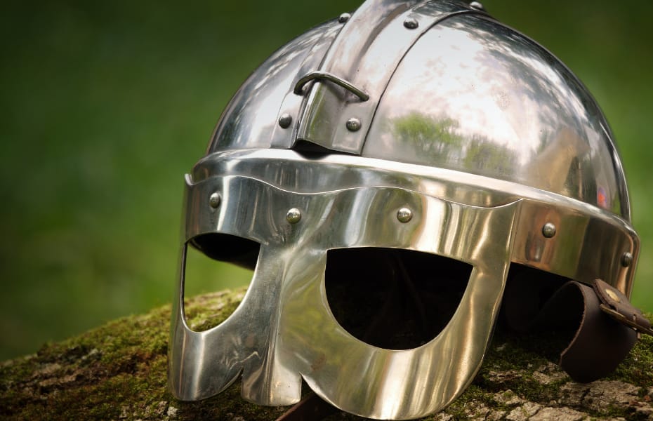 casque medieval en acier posé sur une pierre